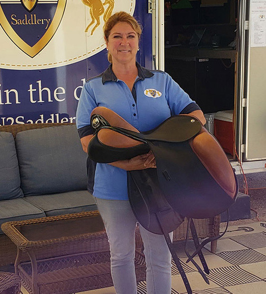 Sue Newell holding a saddle in front of N2 trailer